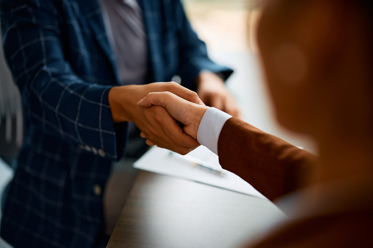 Two people shaking hands in a business deal.