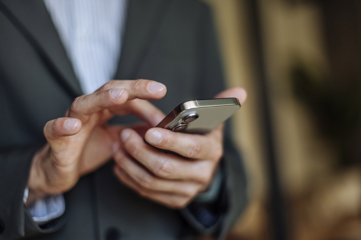 Business professional types on phone.