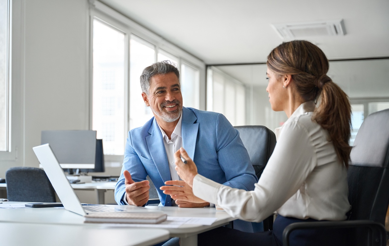Smiling business professionals engage in a discussion.