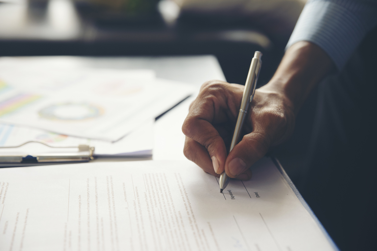 Business professional writes on paper.