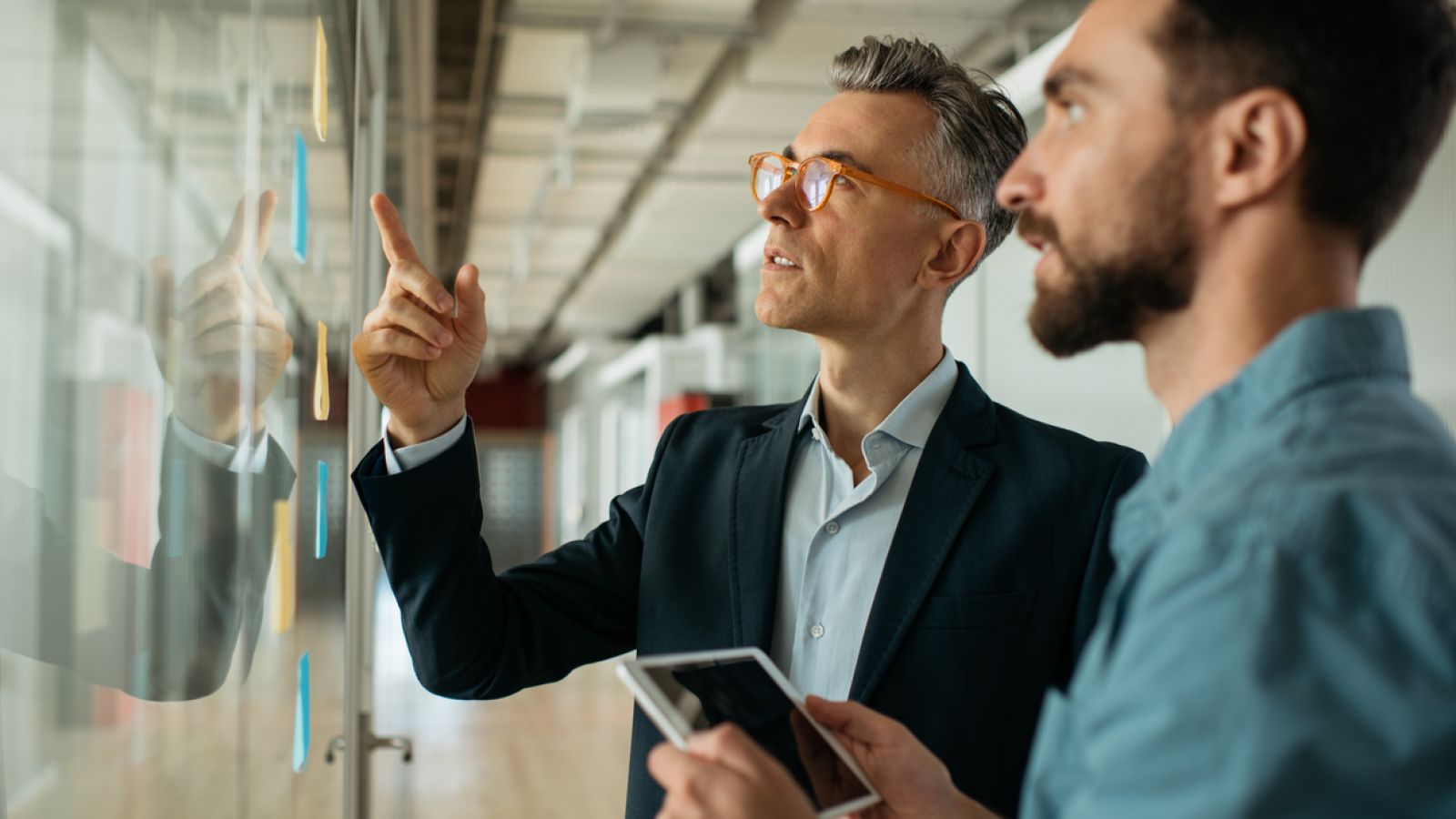 Business professionals point at chart on board.